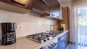 Une cuisine moderne équipée d’une cuisinière à gaz, d’une machine à café et d’un évier.
