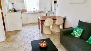 Un espacio habitable compacto con kitchenette, comedor y sofá.