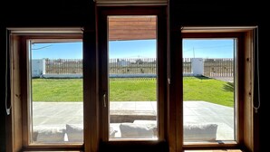 Ein Zimmer mit einer großen Schiebeglasdoor, die zu einer Terrasse im Freien führt.