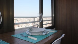 Une table à manger avec une assiette blanche, un verre et une fourchette, le tout posé sur un set de table bleu.