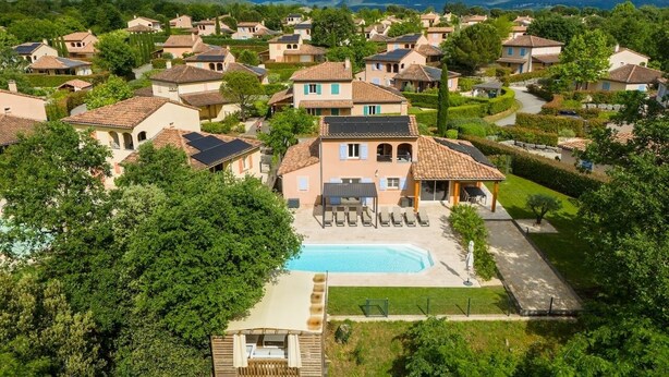 Un barrio residencial con casas, una piscina y una terraza de madera.