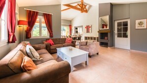 Un salón amplio con un conjunto de sofás, una mesa de centro y una chimenea.