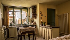 Une cuisine compacte comprenant une table à manger, des chaises et un petit îlot central.