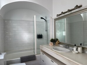 Een bad/douchecombinatie, een haardroger, een bidet, handdoeken