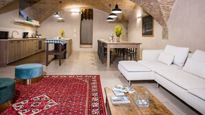 A cozy living area with a white sofa, a red patterned rug, and a wooden coffee table. - Appartamento La Corte (Cortona)