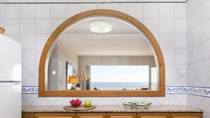 A kitchen with a large mirror, wooden cabinets, and a view of the sea. - SAILOR HOUSE with SEA VIEWS (Tossa de Mar)