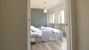 Et soveværelse med en seng, et sengebord og en hængende lampe.