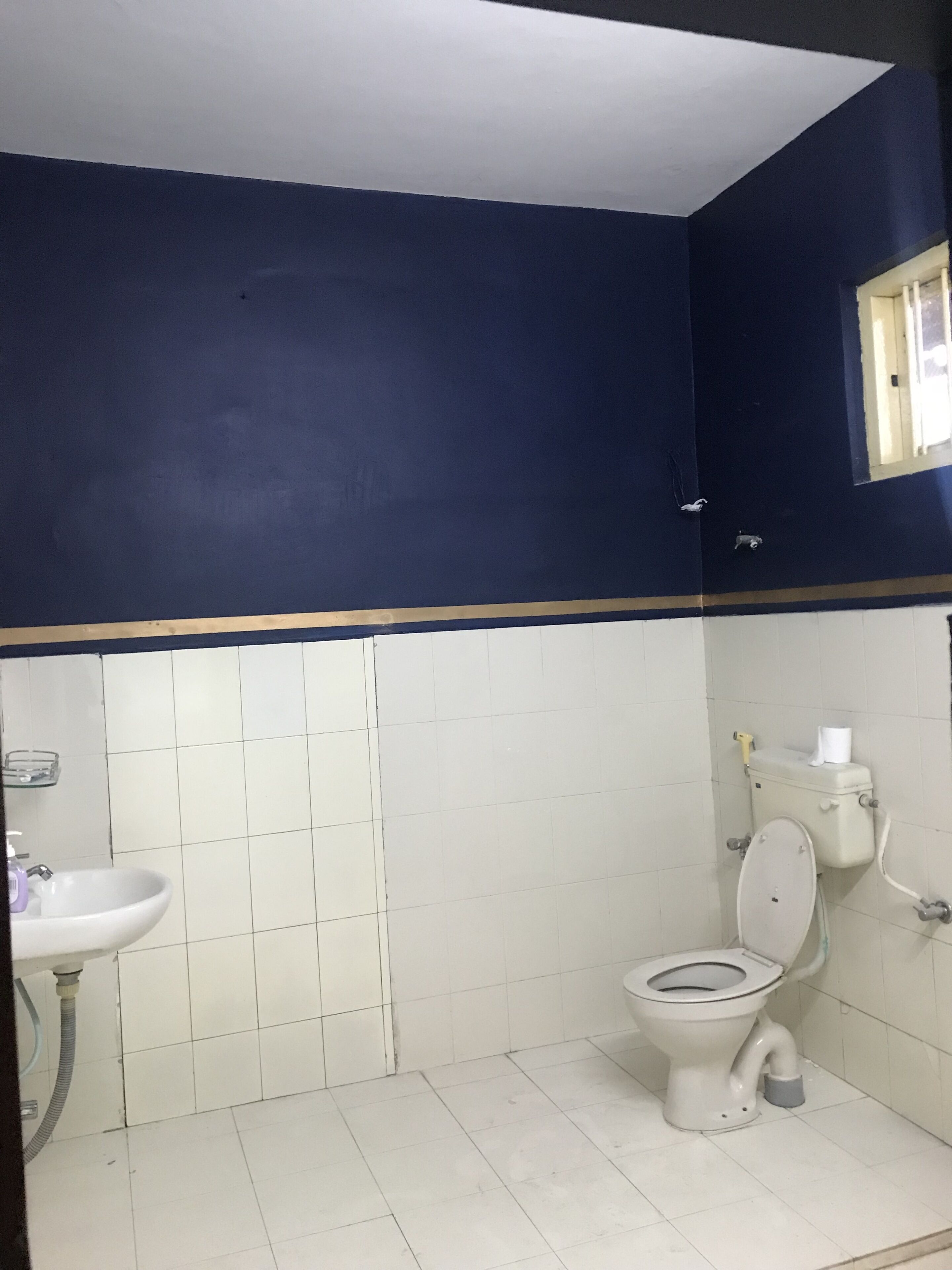 A bathroom with a toilet, sink, and tiled walls.