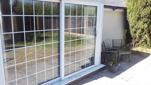 A sliding glass door leading to a patio area with a garden view. - Garden flat, dog friendly, sleeps 3/4, enclosed garden, parking, level access (Tiverton)