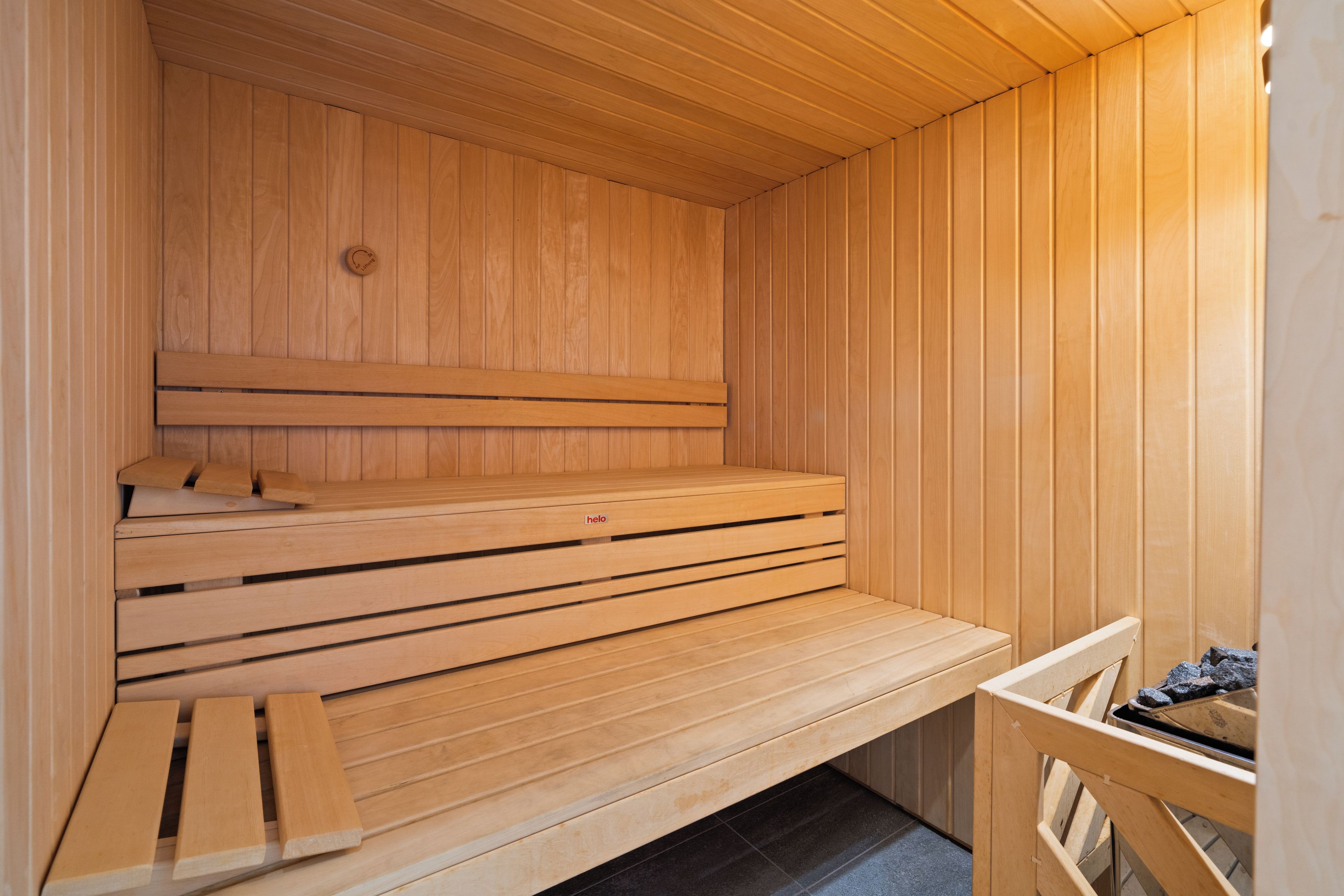 Un sauna avec des bancs en bois et une banquette.