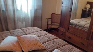 Une chambre à coucher avec un grand lit, une commode en bois, une chaise et un miroir.