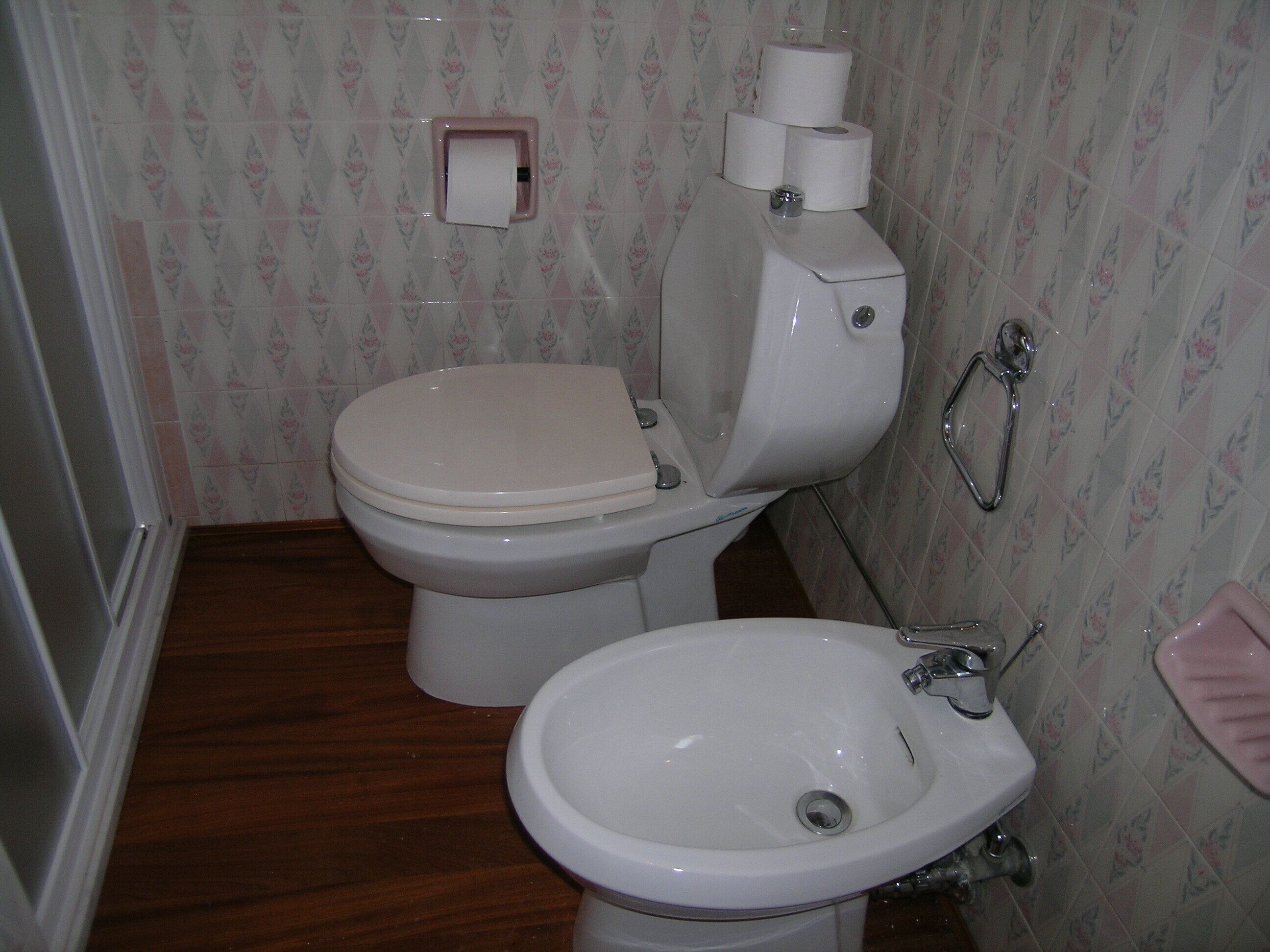 Et badeværelse med toilet, bidet og vask.