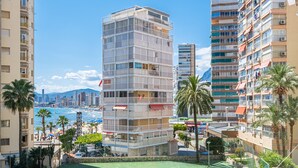 A multi-story building with balconies, a beach view, and palm trees. - Carabelas III 1-3 (Benidorm)