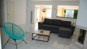 A living room with a sofa, a coffee table, and a turquoise chair.