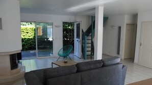 A modern living room with a grey sofa, a teal chair, and a fireplace.