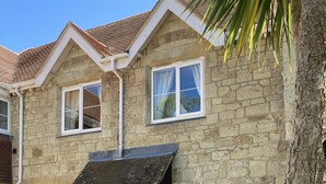 A stone house with a tiled roof, a front porch, and a bench. - Edge of Old Village, close to shops, park and beach; ferry discounts (Shanklin)