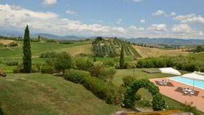 Paisaje de viñedo con piscina y zona de estar al aire libre.