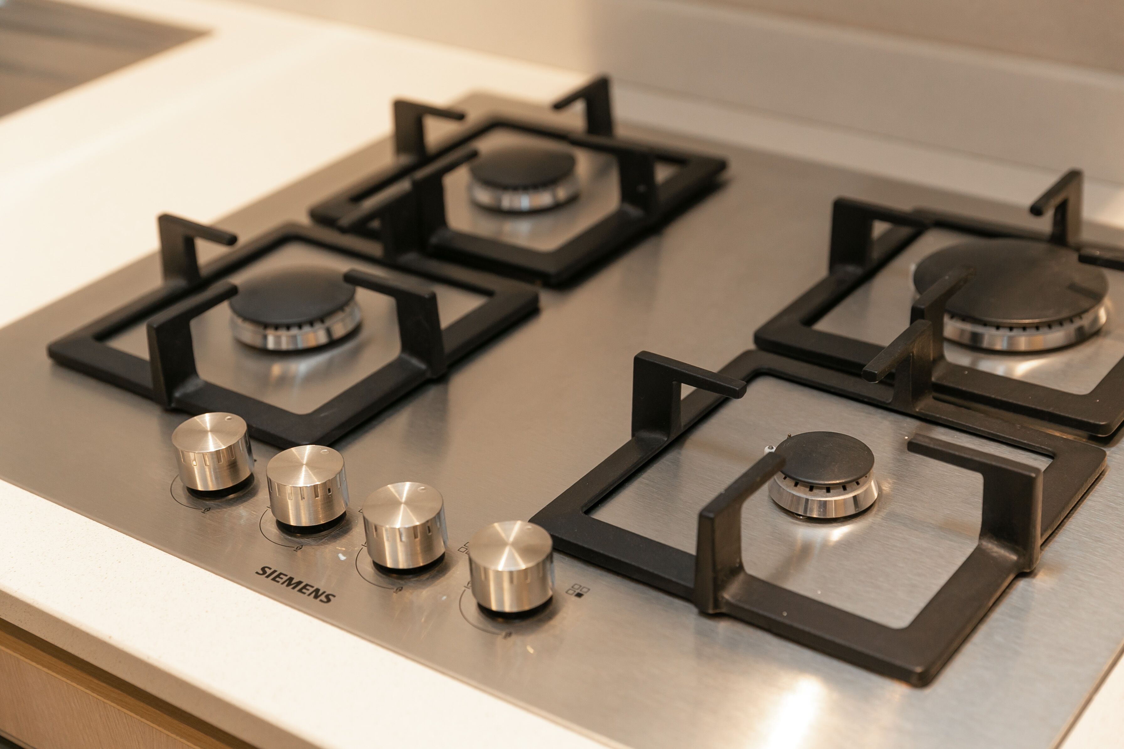 Een keuken met een Siemens gasfornuis, vier branders en vier knoppen.