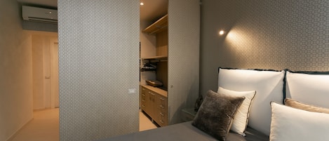 Une chambre à coucher avec un lit, des oreillers, une armoire et une commode.