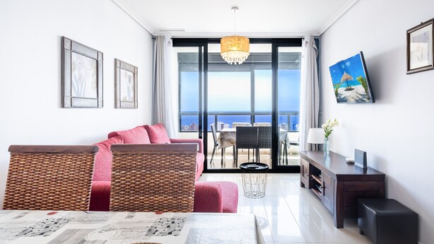 Una sala de estar moderna con un sofá, una mesa de comedor y vistas al océano.