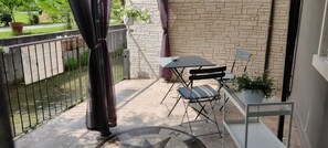 A balcony with a table and chairs, a potted plant, and a stone wall. - The rose of the winds vacation home IT024097C2LMWLOL4M (Sarcedo)
