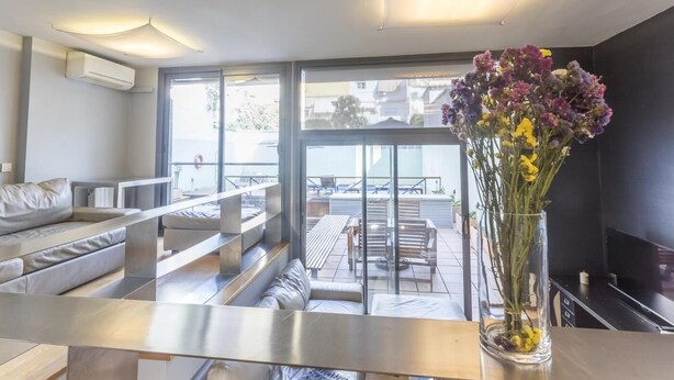 Un salon moderne avec un canapé, une table basse et un vase de fleurs.
