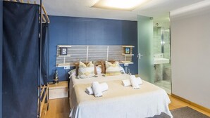 Une chambre à coucher avec un lit, une table de chevet et un luminaire suspendu.