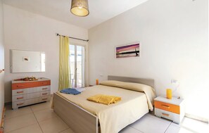 A bedroom with a bed, a nightstand, a dresser, a mirror, and a painting on the wall.