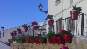 A building with multiple balconies adorned with potted plants. - Casilla Daleá, Andalusia center, Natural Park, by Planetrural (Carcabuey)