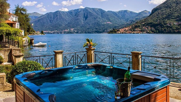 Ein Whirlpool mit Blick auf einen See und Berge.