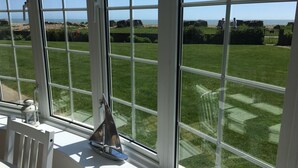 A view from a window with a sailboat model on the windowsill. - Stunning Beachfront Apartment on Ferring beach (Ferring)