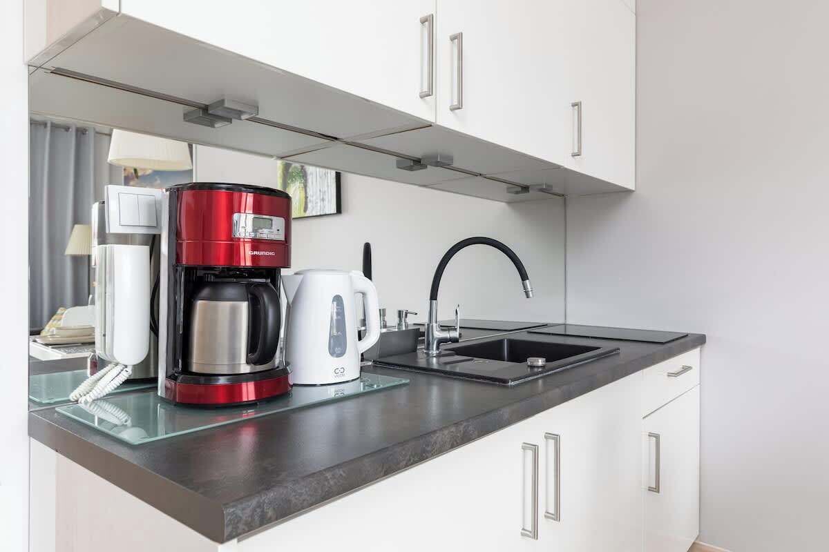 Eine moderne Küche mit Kaffeemaschine, Wasserkocher und Spüle.