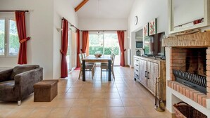 Uma sala de estar ampla com lareira, área de jantar e cozinha.