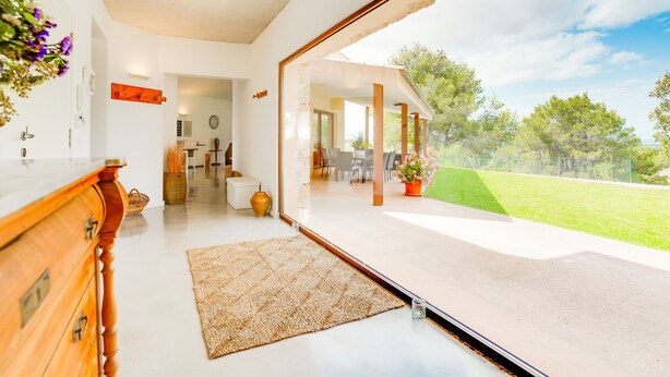 Ein modernes Interieur mit einer großen Glastür, die zu einer Außenpatio führt.