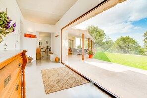 A modern interior with a large glass door leading to an outdoor patio. - SON VADOR Finca with pool for 8 in Santa Margalida (Santa Margalida)