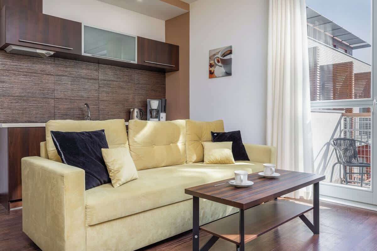 A modern living room with a sofa, a coffee table, and a view of the outside.