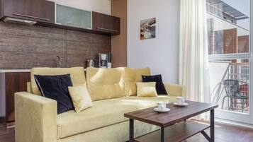 A modern living room with a sofa, a coffee table, and a view of the outside.