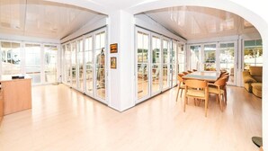Une pièce spacieuse avec une grande table à manger, des chaises et un canapé.