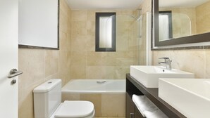 A bathroom with a toilet, bathtub, and two sinks. - 2 bedroom apartment front sea view (Torrox Costa)