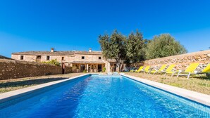 Une piscine avec un bâtiment en pierre en arrière-plan.