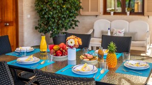 A dining table set with plates, cutlery, glasses, and a pineapple centerpiece.