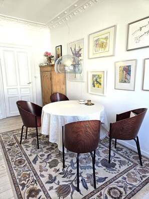 A dining area with a round table, four chairs, a patterned rug, and artwork on the walls. - City Apartment in Copenhagen with 1 bedrooms sleeps 4 (Copenhagen)