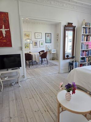A room with a TV, a dining area, a bookshelf, and a window. - City Apartment in Copenhagen with 1 bedrooms sleeps 4 (Copenhagen)