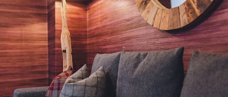 A wooden wall with a circular mirror and a lamp.