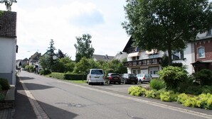 A residential street with parked cars and houses on both sides. - Haus Buchholz Apartment 2 multiple apartments available (Liesenich)