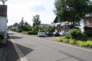 Stroll through a charming residential street lined with traditional houses featuring balconies and pitched roofs.
