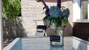 A glass table with a vase of flowers and a chalkboard sign. - Cozy house with garden / near Simssee (Stephanskirchen)