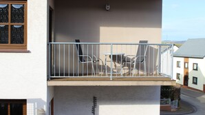 A balcony with a metal railing, two chairs, and a small table. - High quality, modern with infrared sauna. Awarded 4 stars by the DTV. (Lierschied)