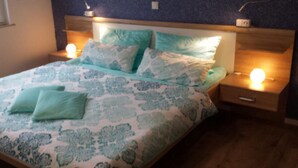 A bed with a patterned bedspread, two bedside lamps, and a wooden headboard. - High quality, modern with infrared sauna. Awarded 4 stars by the DTV. (Lierschied)
