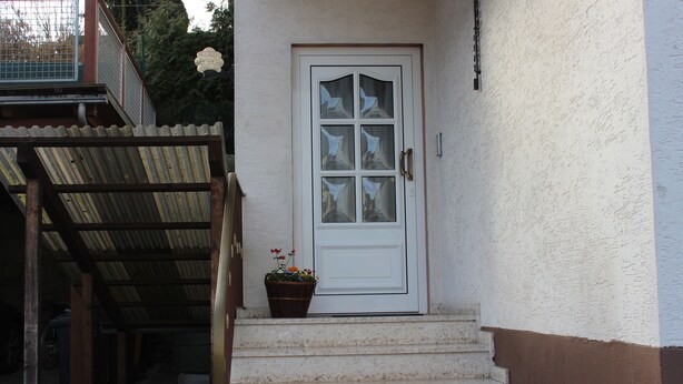 A white door with six glass panels and a handrail leading to a covered entrance. - High quality, modern with infrared sauna. Awarded 4 stars by the DTV. (Lierschied)